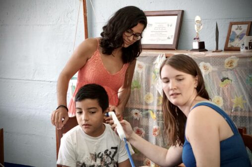 La Conexión at San Josecito in Costa Rica - Two health experts examining a young boy