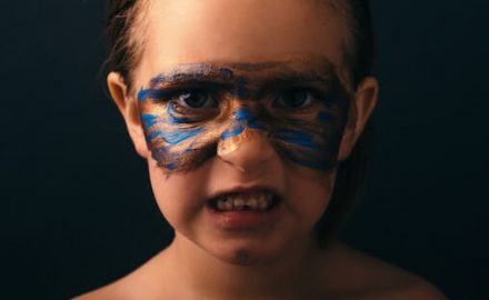 Child in makeup acting angry, like she has behavior problems.