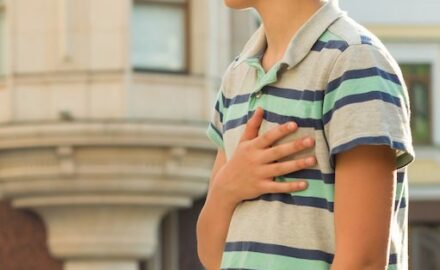 Teen age boy with hand on chest. Breast lumps in boys is a common condition.