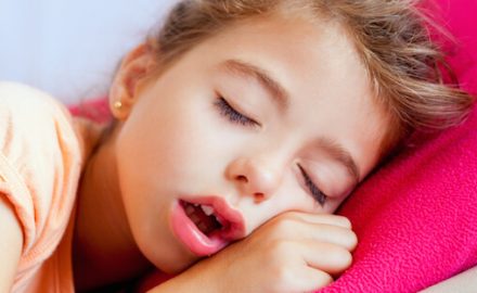 Girl sleeping very deeply. Deep sleep is one factor in enuresis.