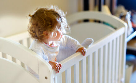 Child standing in a crib after waking up. Children's Dreams Nightmares and Night Terrors.