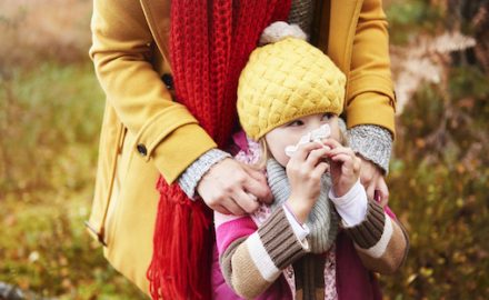 Mom and daughter bundled up in coats in a cold outdoor scene. How do cold air and colds fit together?