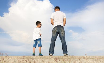 Father and son peeing over a wall. Double urethra is a very rare condition found only in boys.