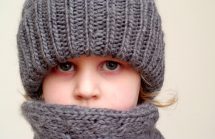 Sad child in winter scarf and hat. Holiday Depression