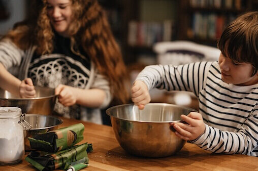 Teen and school age siblings baking. Peer pressure nutrition