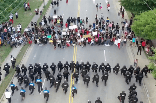 2020 image of police and protestors kneeling during a George Floyd protest.
