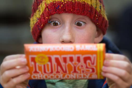 Boy looking enthusiastically at a chocolate bar. What is the relationship between sugar and behavior in children?