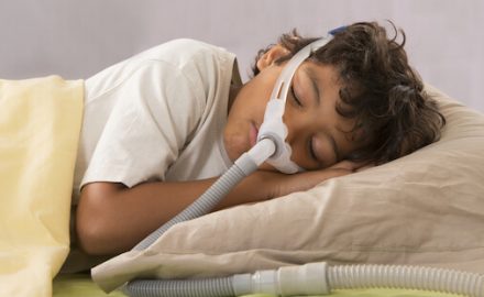 Young boy wearing a CPAP machine for sleep apnea.