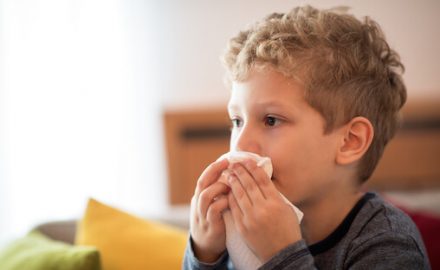 Boy blowing his nose. Stuffy nose and cough for kids.