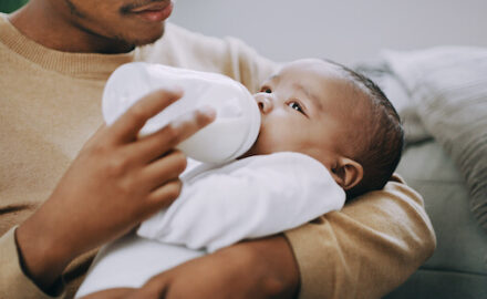 Father feeding an infant a bottle - surprising infant formula ingredients