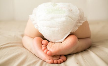 Baby in a diaper from behind. Which diapers are best for the environment?