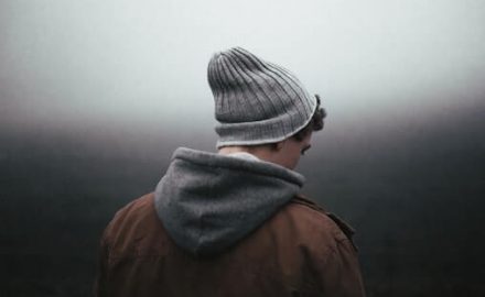 Teenage boy walking away from the camera on a foggy, gloomy day. Does he need Zoloft for depression?