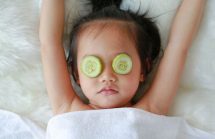 Child with cucumbers on her eyes to ease itchy eyes.
