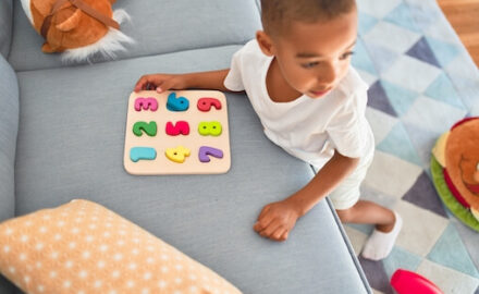 Young boy playing with a puzzle. Play childs work.