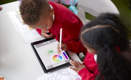 Two black children drawing on a tablet. Screen time quarantine.
